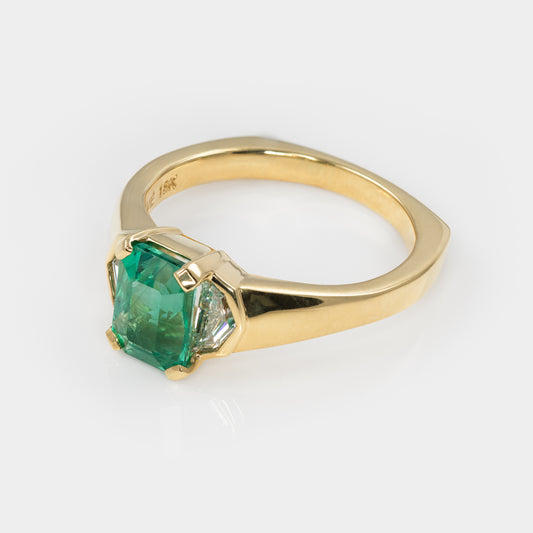 Gold ring with a green gemstone on a white background
