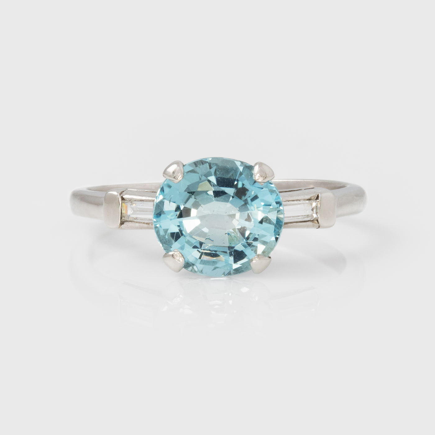 Platinum ring with a blue gemstone on a white background