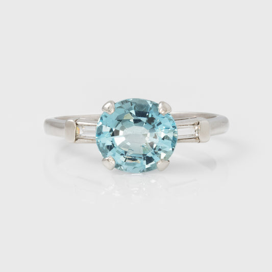 Platinum ring with a blue gemstone on a white background