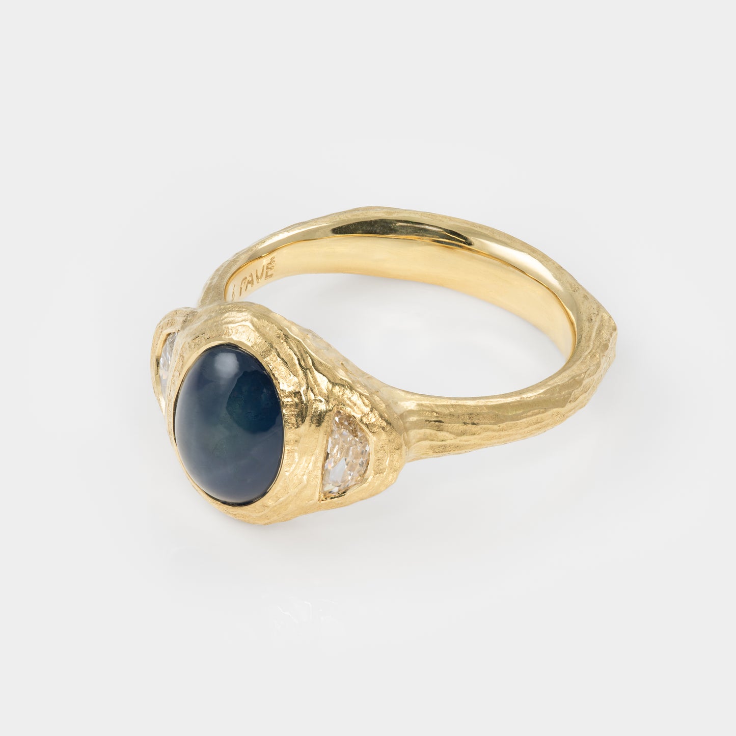 Gold ring with blue star sapphire and side diamonds on white background 3/4 view