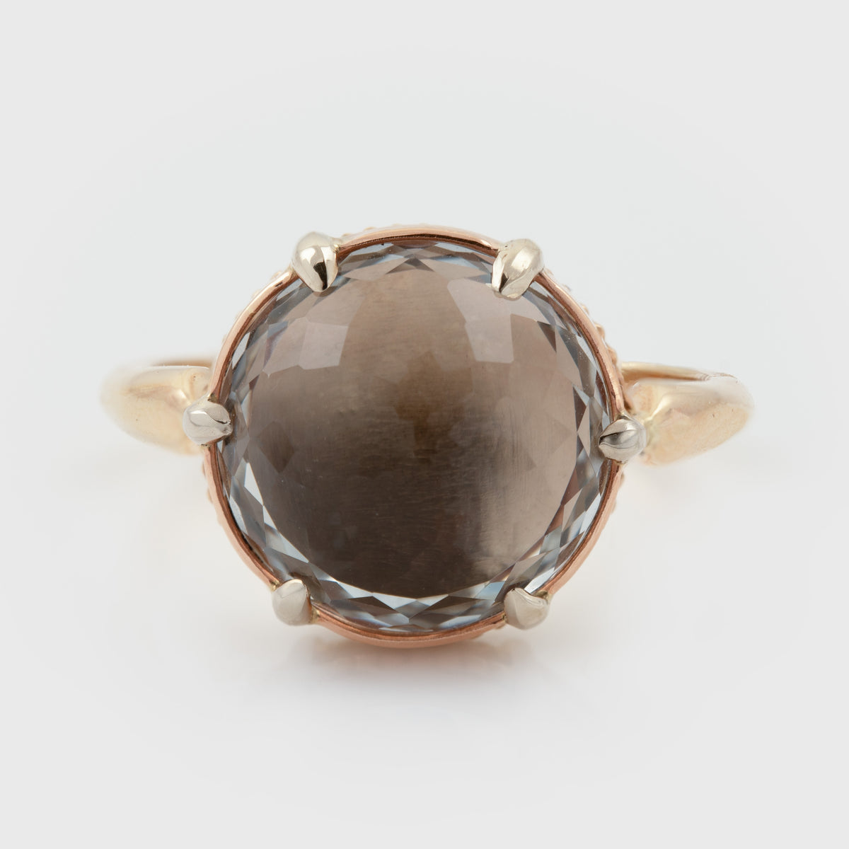 Tri-color gold ring featuring a large champagne topaz center stone, photographed on a white background.