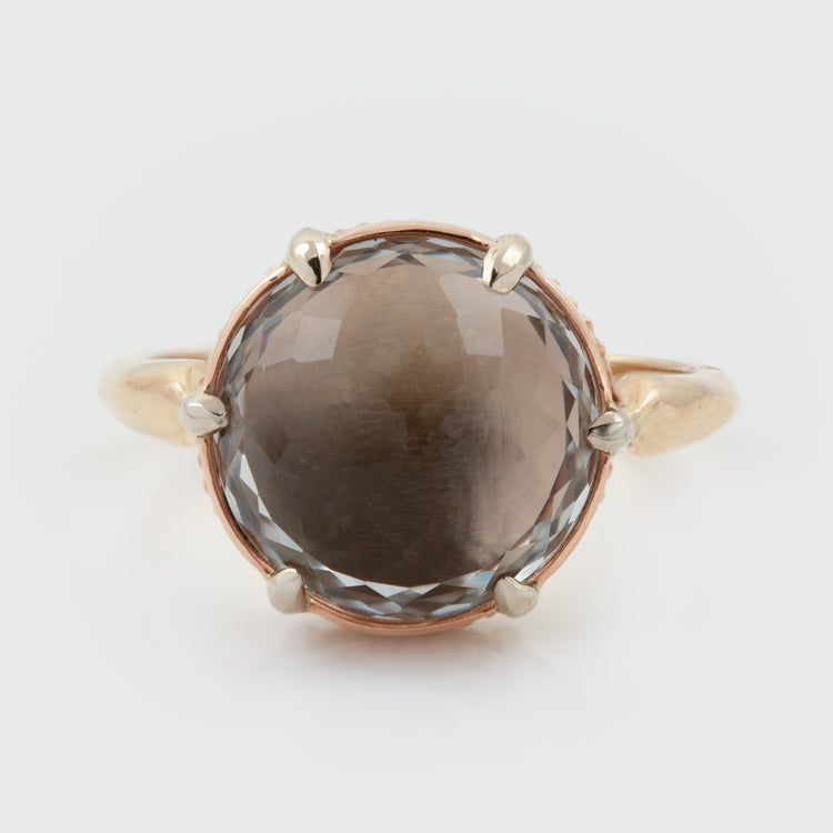 Tri-color gold ring featuring a large champagne topaz center stone, photographed on a white background.
