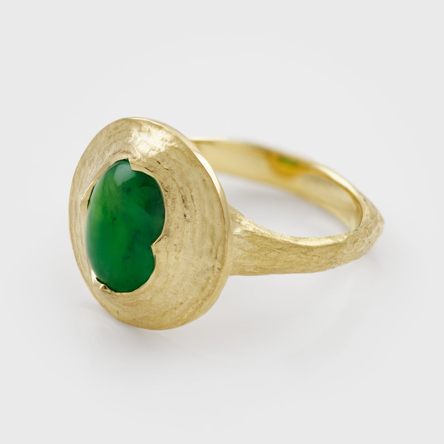Side view of yellow gold ring featuring oval cabochon green Jade