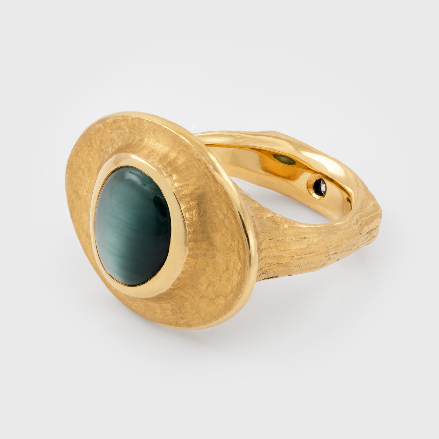 Side view of yellow gold ring featuring bezel set blue green Cat's Eye Tourmaline