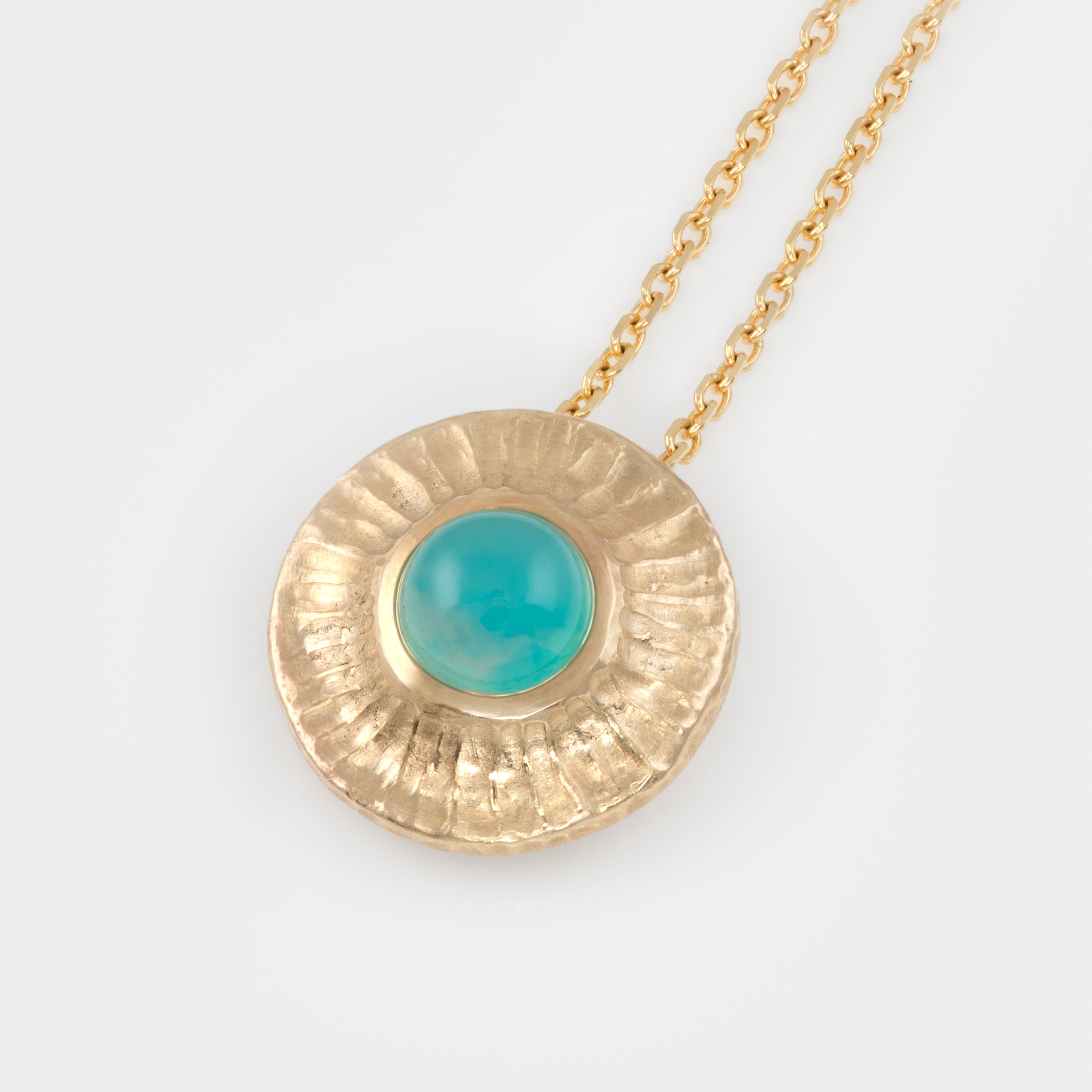 Gold necklace with a blue green chrysocolla pendant on a white background