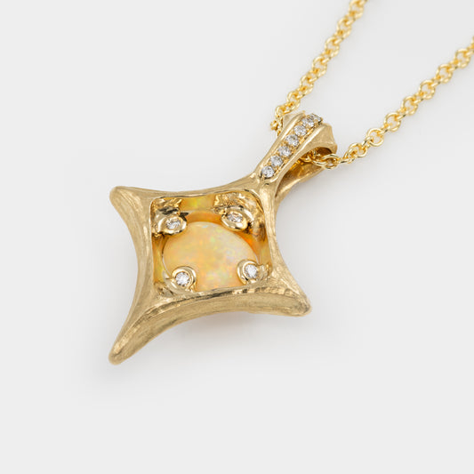 Back view of gold pendant with opal stone and four diamonds setting on a white background