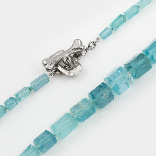 Necklace with blue beads and a platinum clasp on a white background