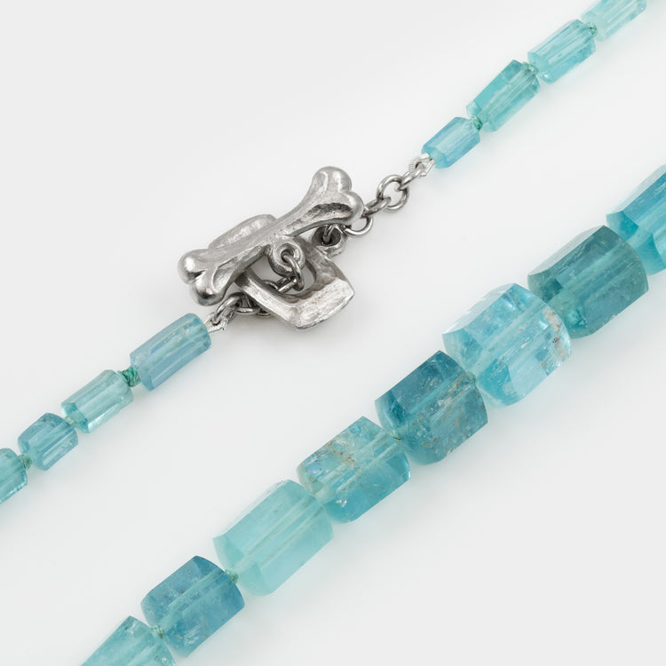 Necklace with blue beads and a platinum clasp on a white background