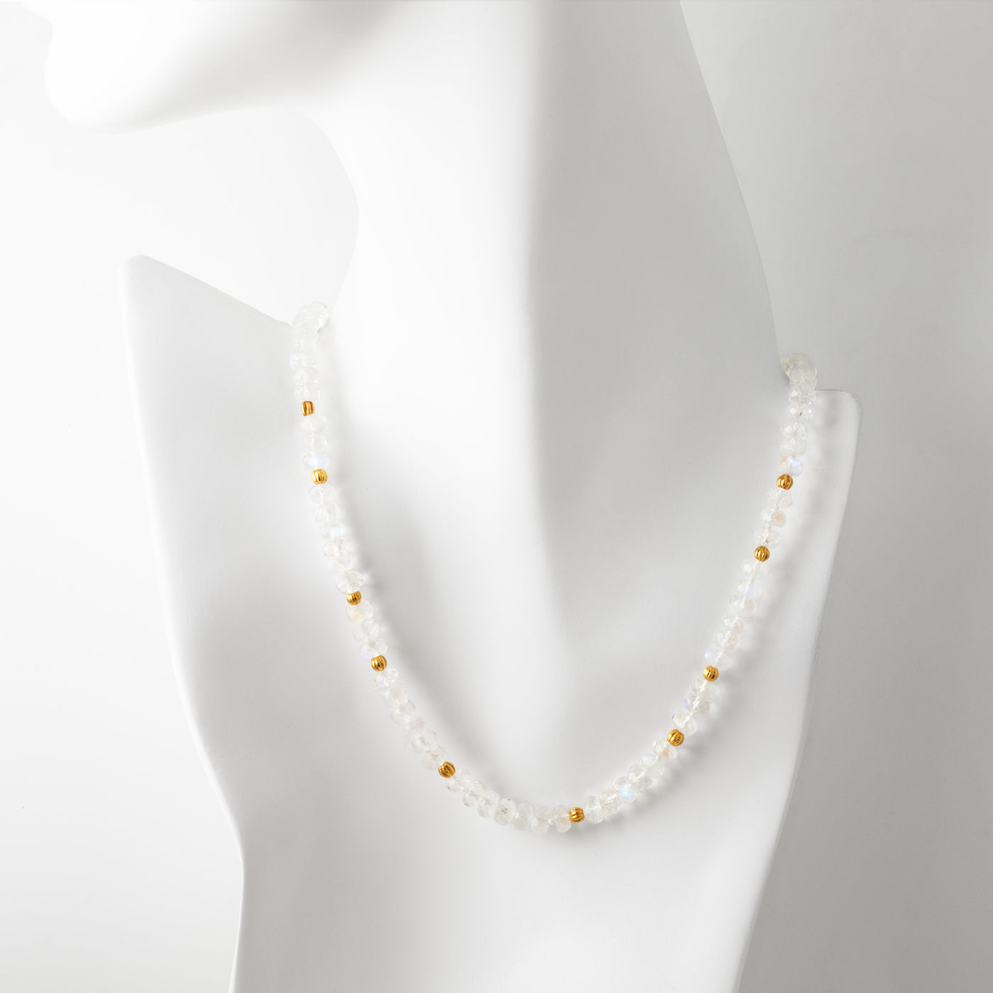 Moonstone necklace with gold accents on a mannequin against a white background