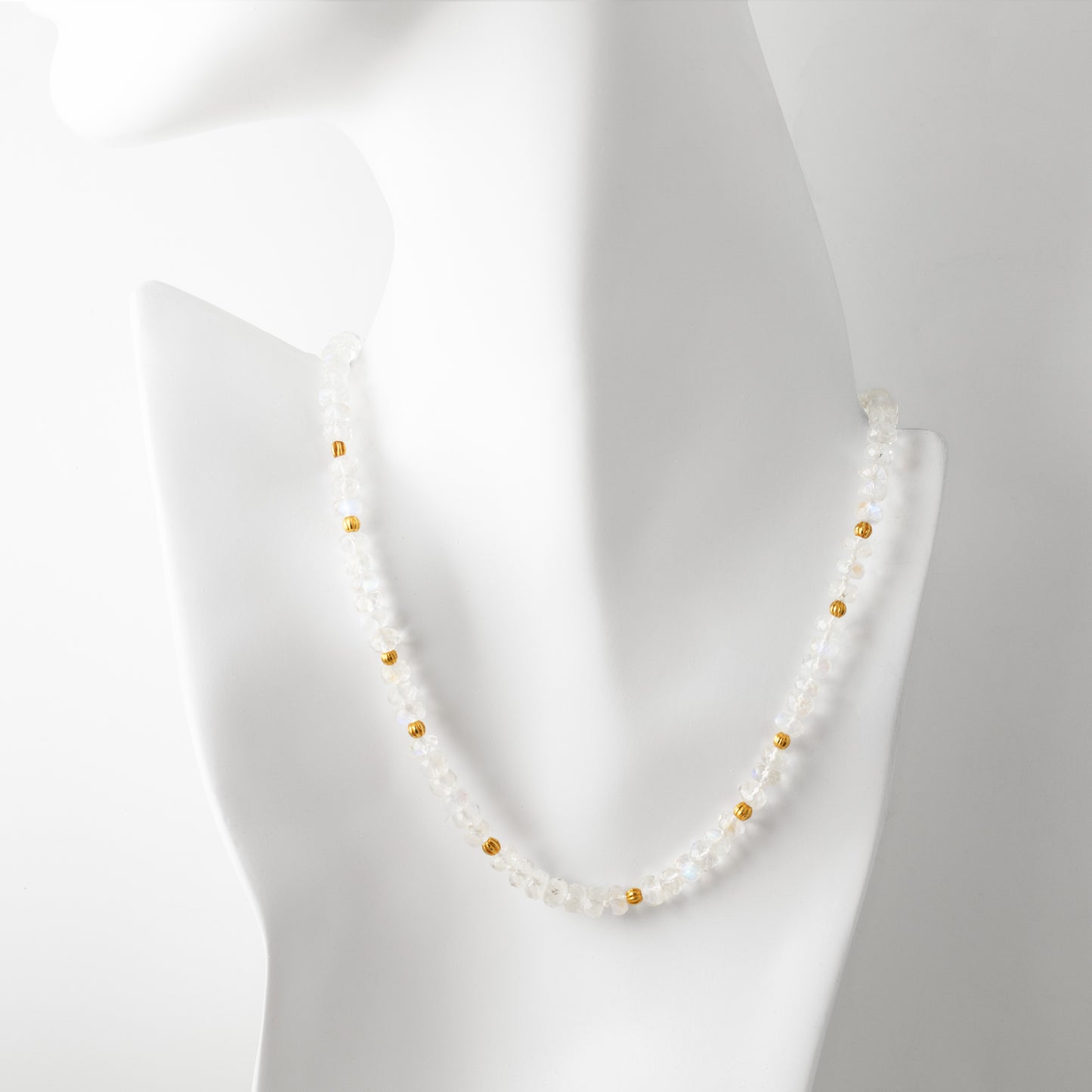 Moonstone necklace with gold accents on a mannequin against a white background