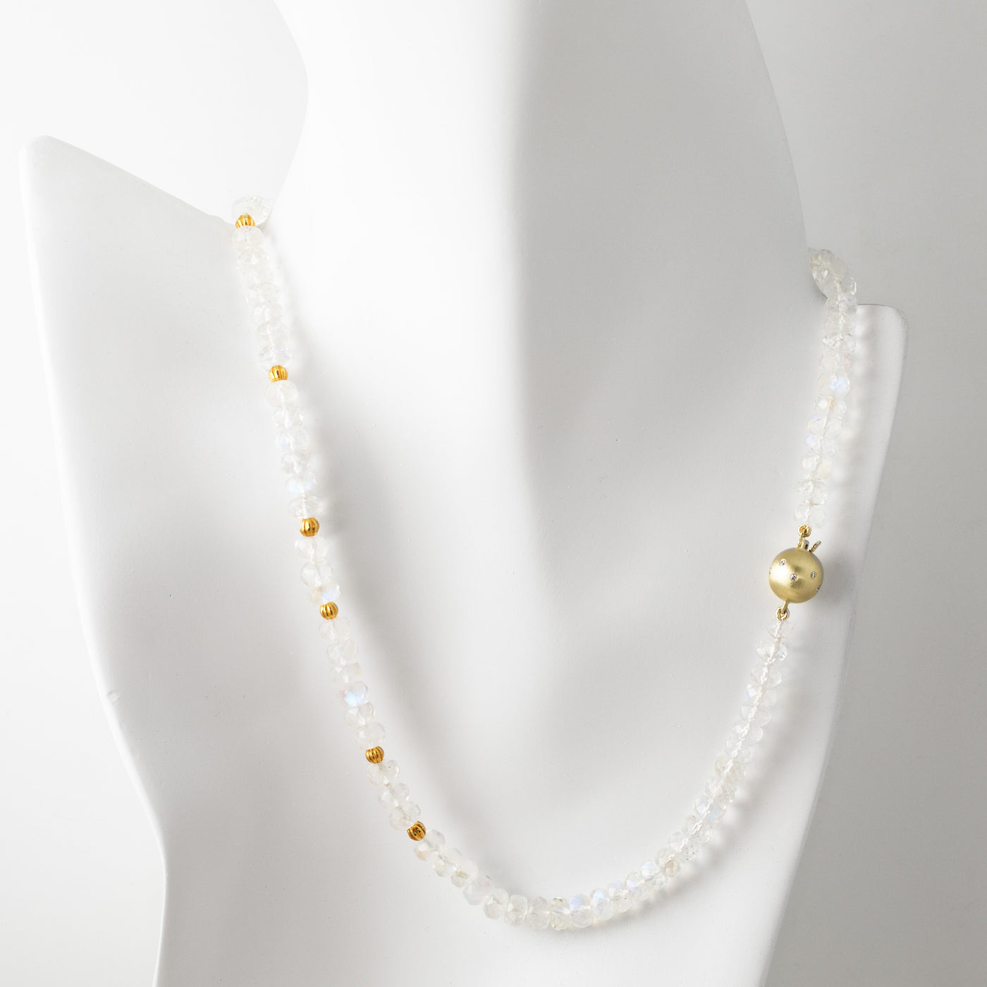 Moonstone necklace with gold accents on a mannequin against a white background