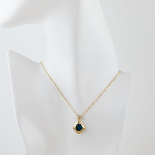 Gold natural texture necklace with a blue and green opal gemstone and accent diamond on a white mannequin