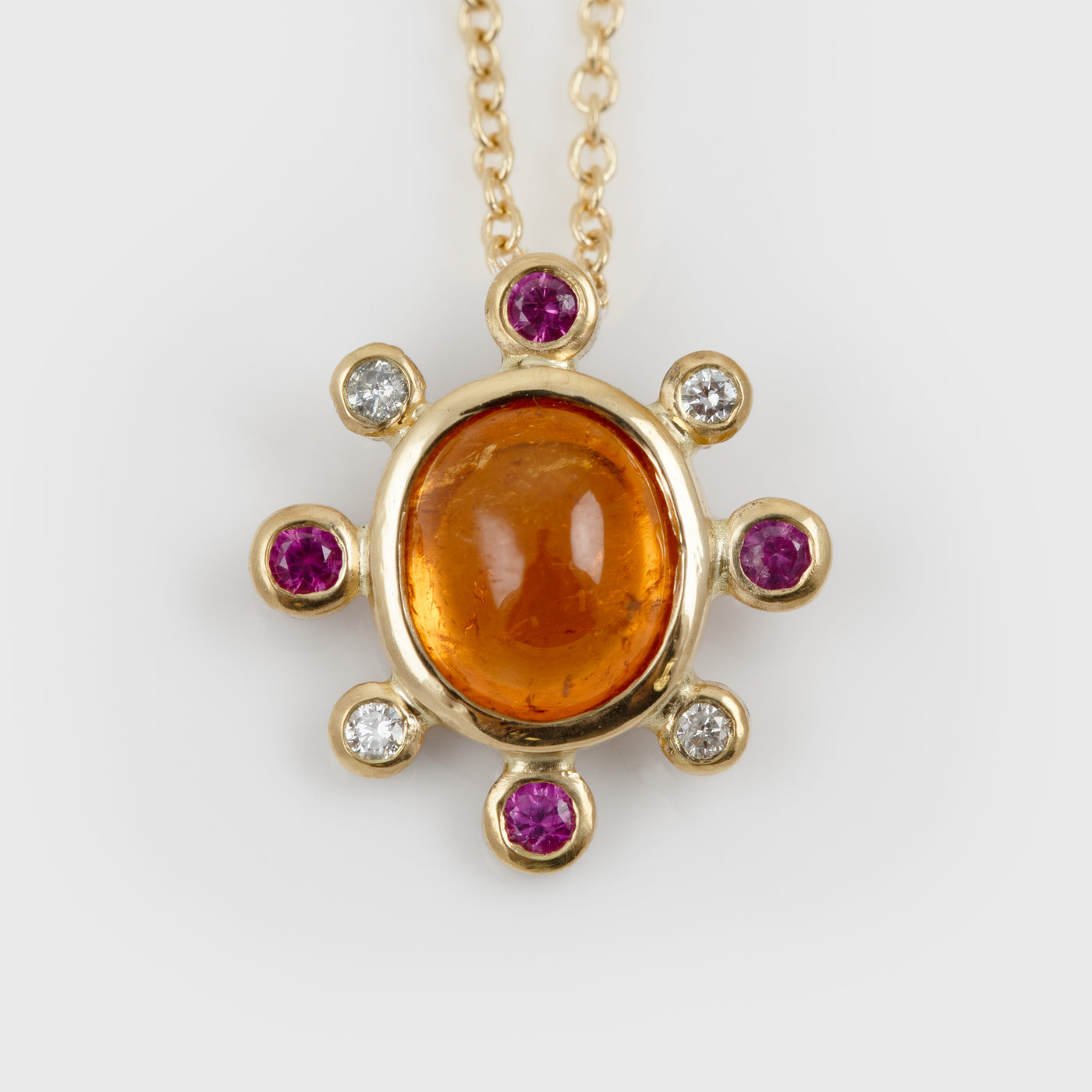 Yellow gold necklace featuring orange Garnet, pink Sapphires, and white Diamonds