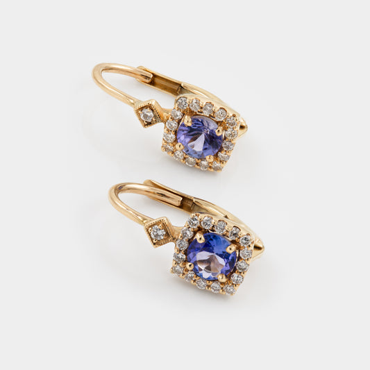 Gold earrings with Tanzanite gemstones on a white background