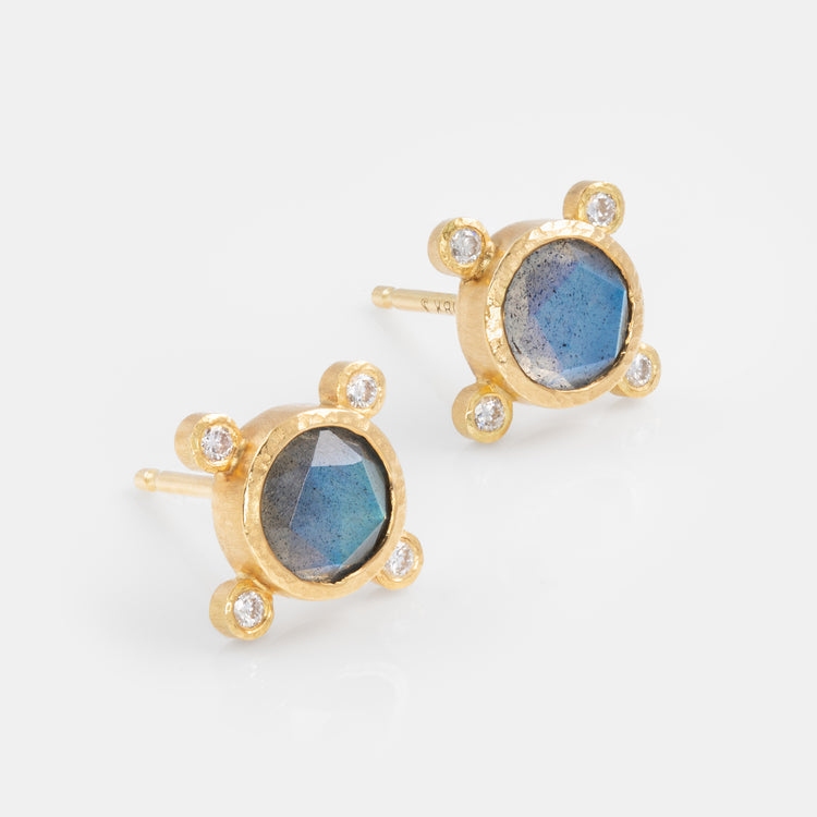 Gold earrings with blue gemstones and diamond accents on a white background