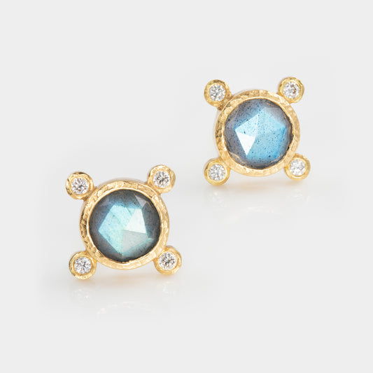 Gold earrings with blue gemstones and diamond accents on a white background