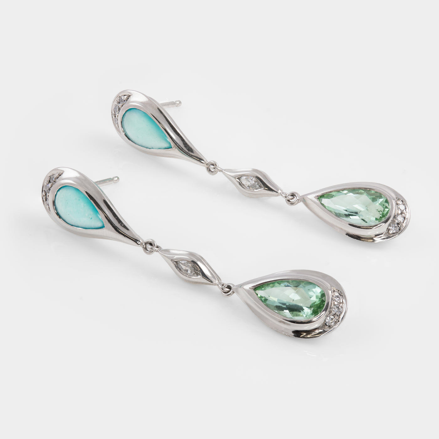 Pair of earrings with green gemstones on a white background