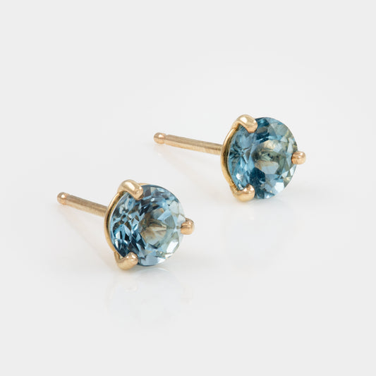 Pair of gold earrings with Aquamarine gemstones on a white background