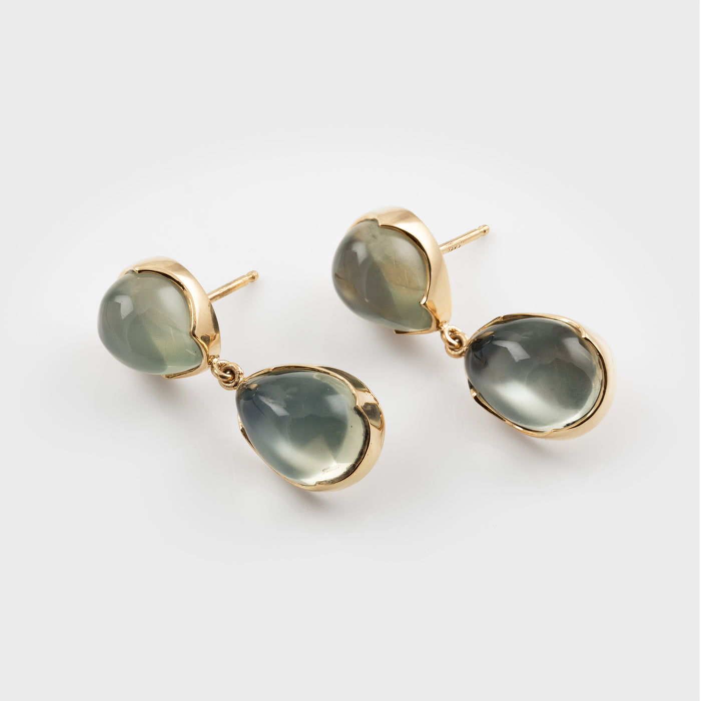 Green moonstone gemstone earrings on a white background