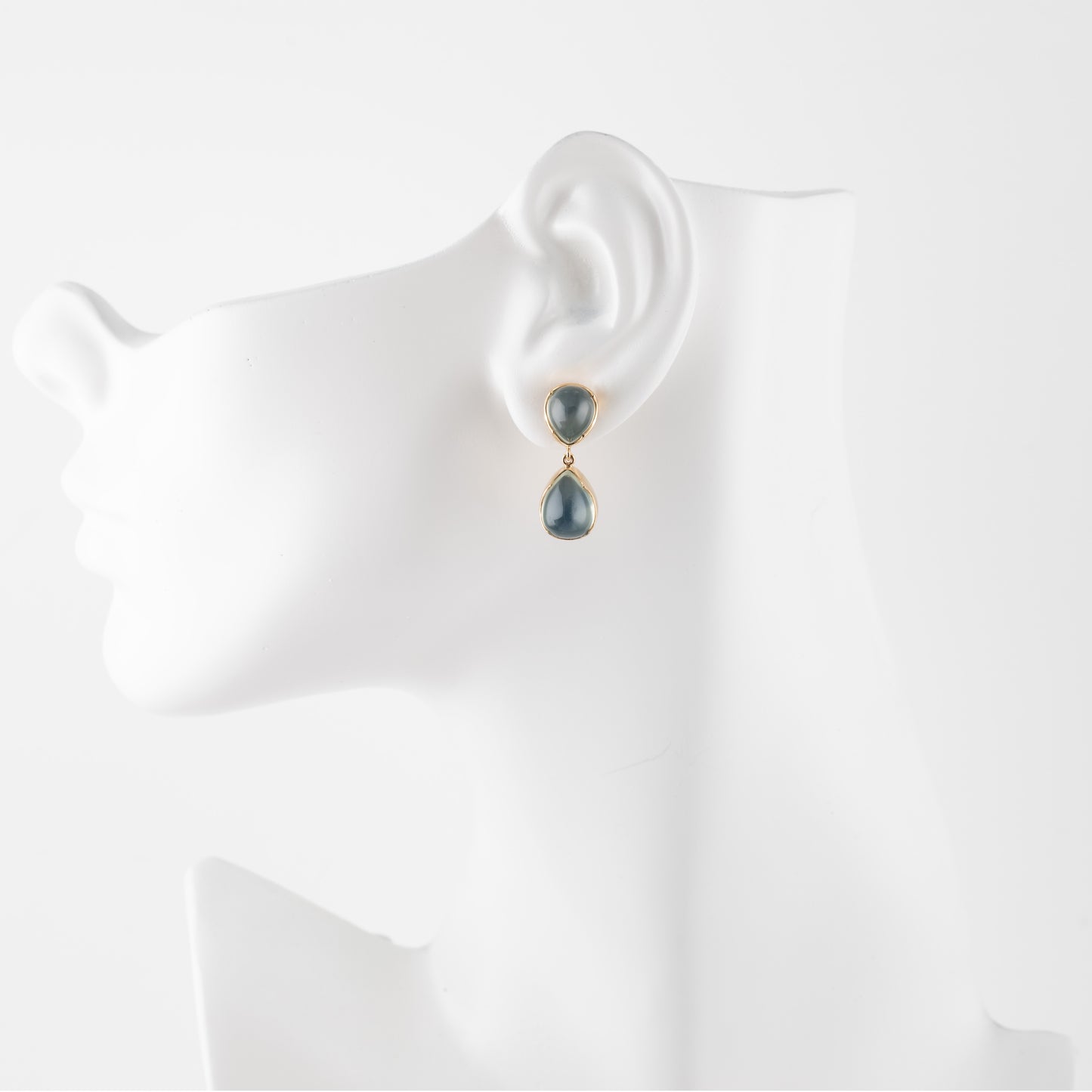 Green moonstone gemstone earrings on a white mannequin