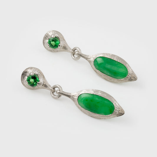 Pair of silver earrings with green stones on a white background