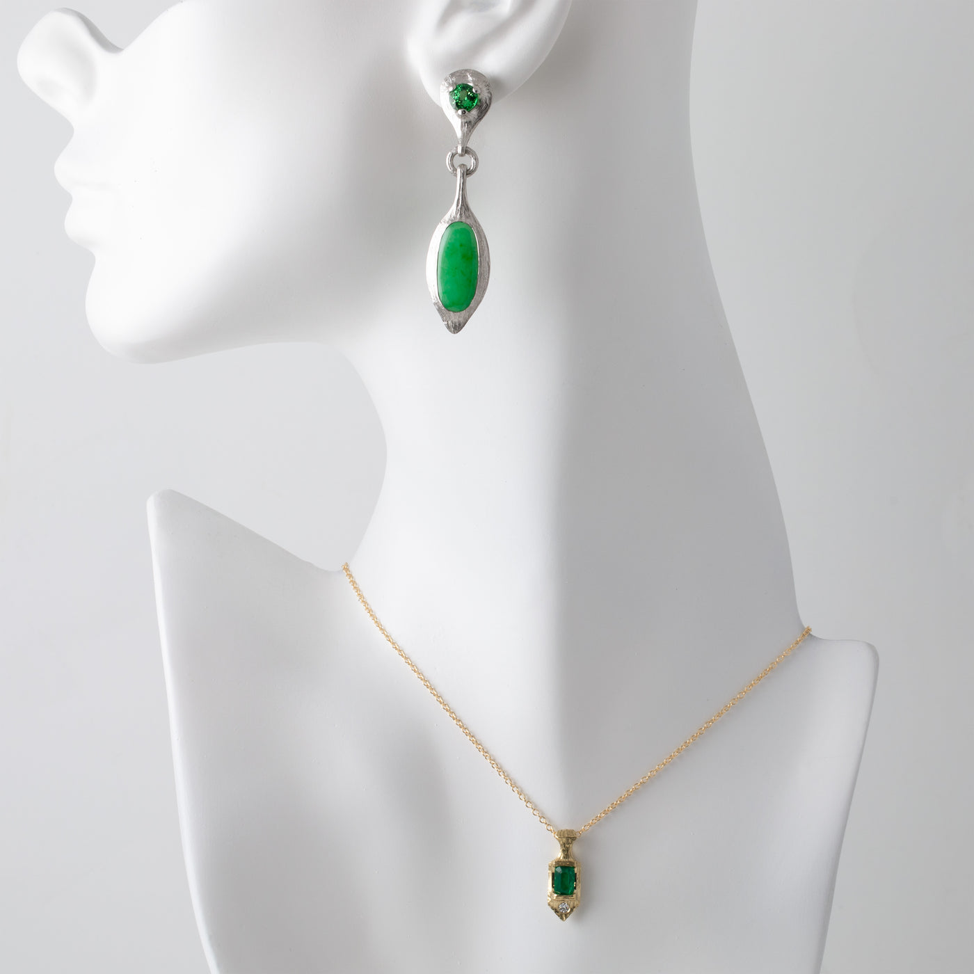 Green gemstone necklace and earring set on a mannequin with a white background