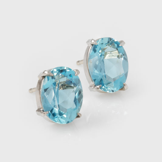 Pair of blue gemstone earrings on a light gray background