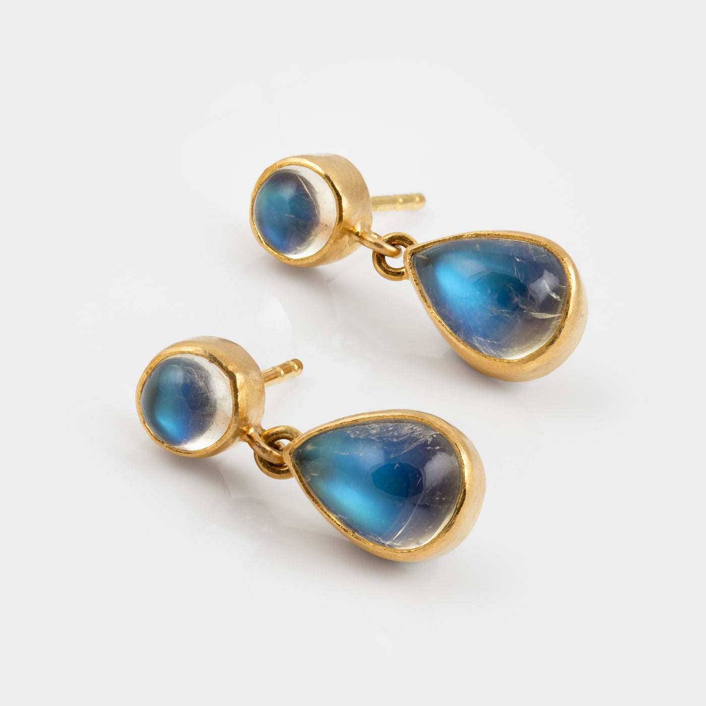 A pair of gold drop earrings with teardrop-shaped blue iridescent moonstones, shown on a clean white background.