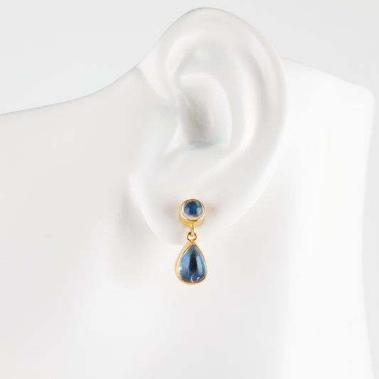 A gold teardrop stud earring, displayed on a white ear-shaped mannequin bust.