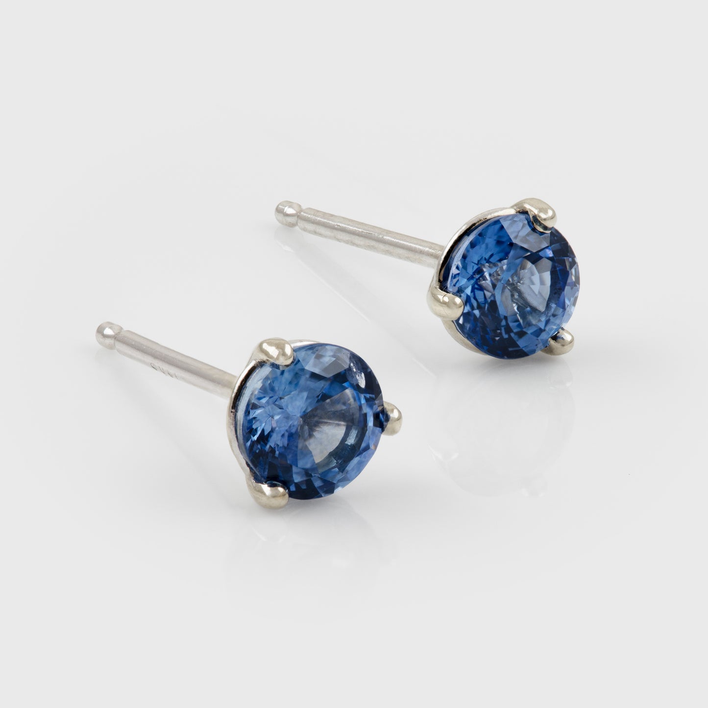 White gold stud earrings featuring round blue Sapphires