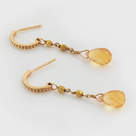 Yellow gold earrings featuring faceted citrine drops with geometric gold bead accents, photographed on a white background.