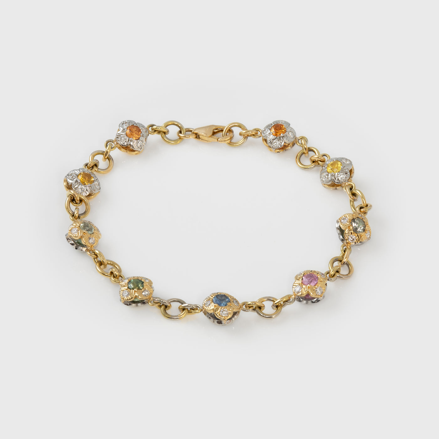 Gold bracelet with colorful gemstones on a white background