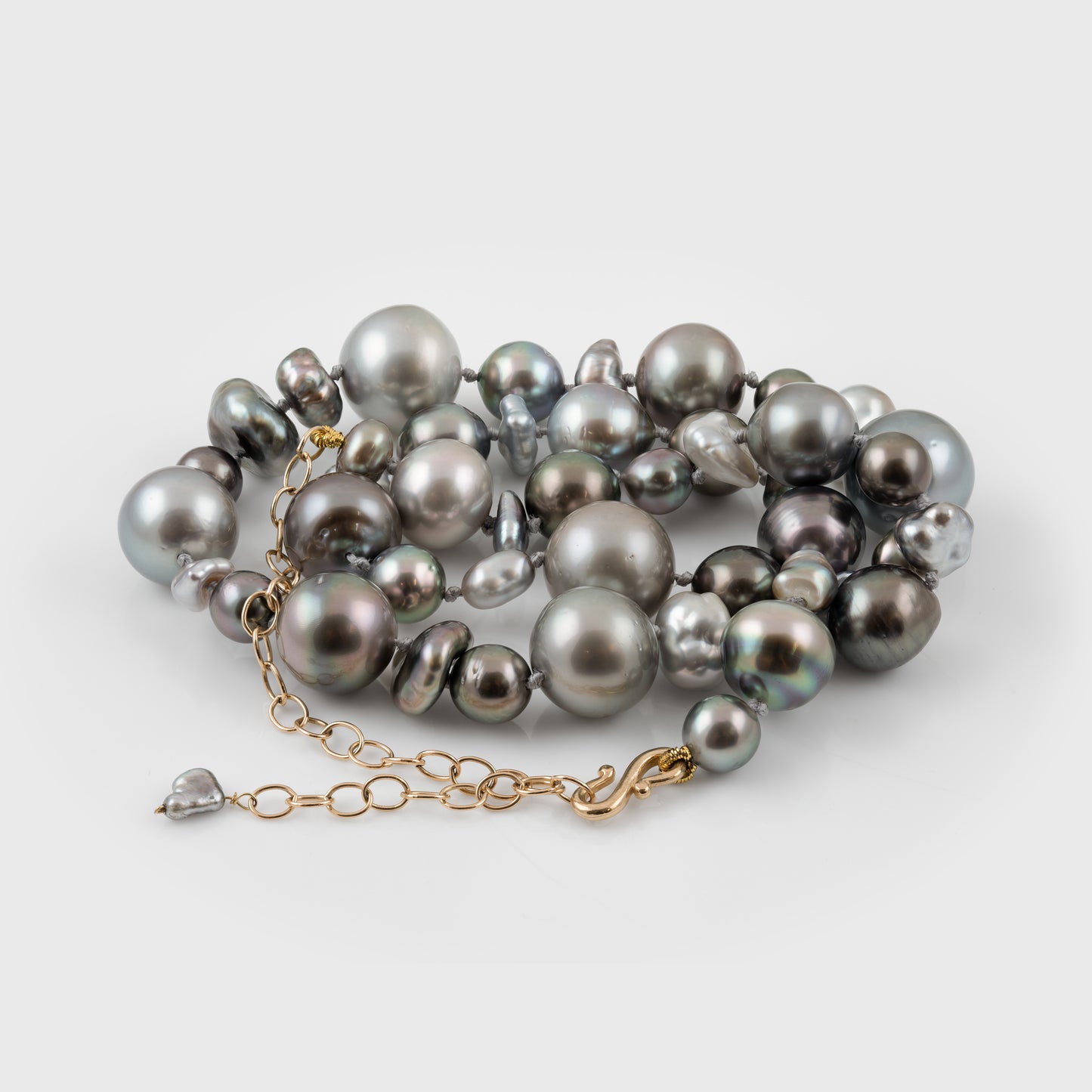 Gray pearl necklace with a gold chain on a white background