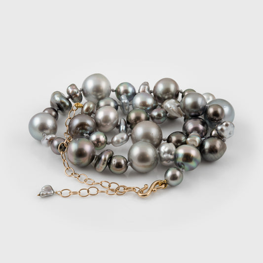 Gray pearl necklace with a gold chain on a white background