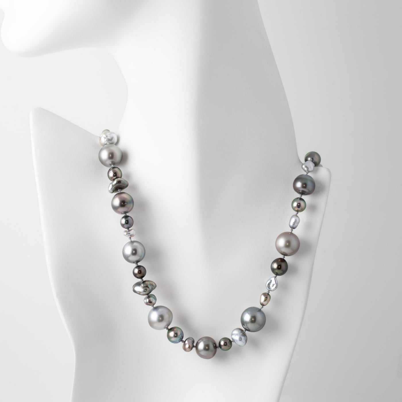Necklace with gray pearls on a mannequin bust against a white background