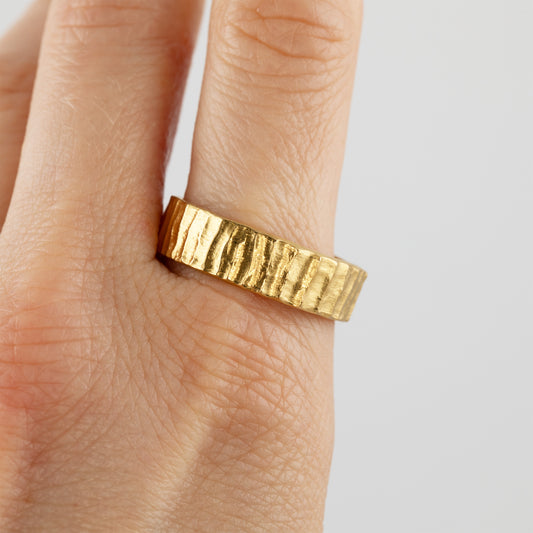 Gold band with redwood bark texture on hand