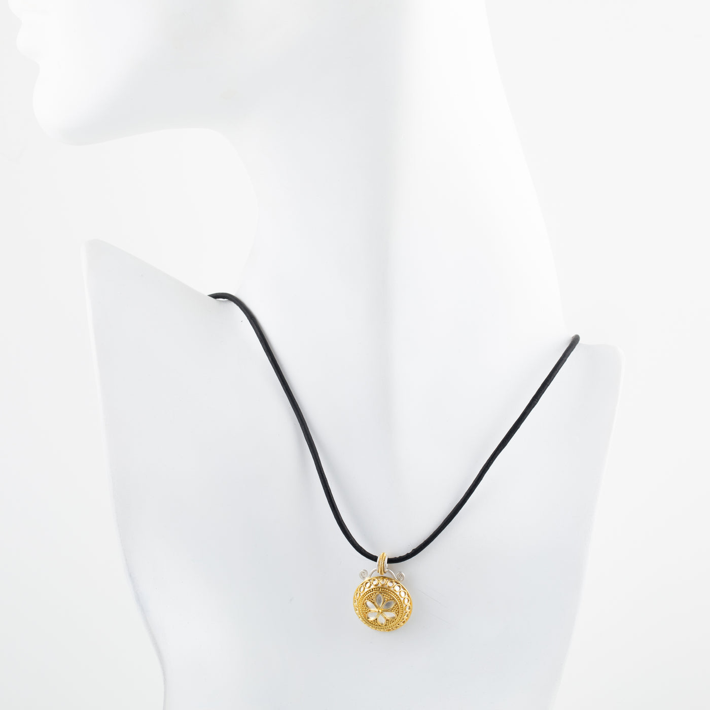 Gold and silver pendant necklace on a white mannequin