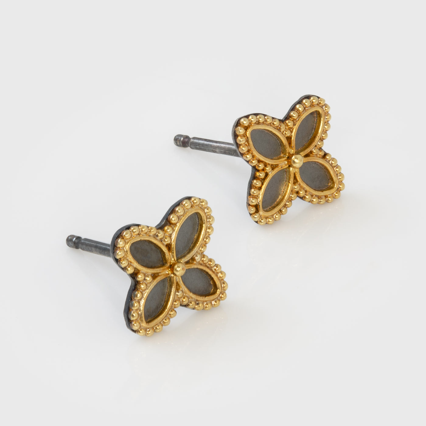 Clover-shaped earrings with gold and black design on a white background
