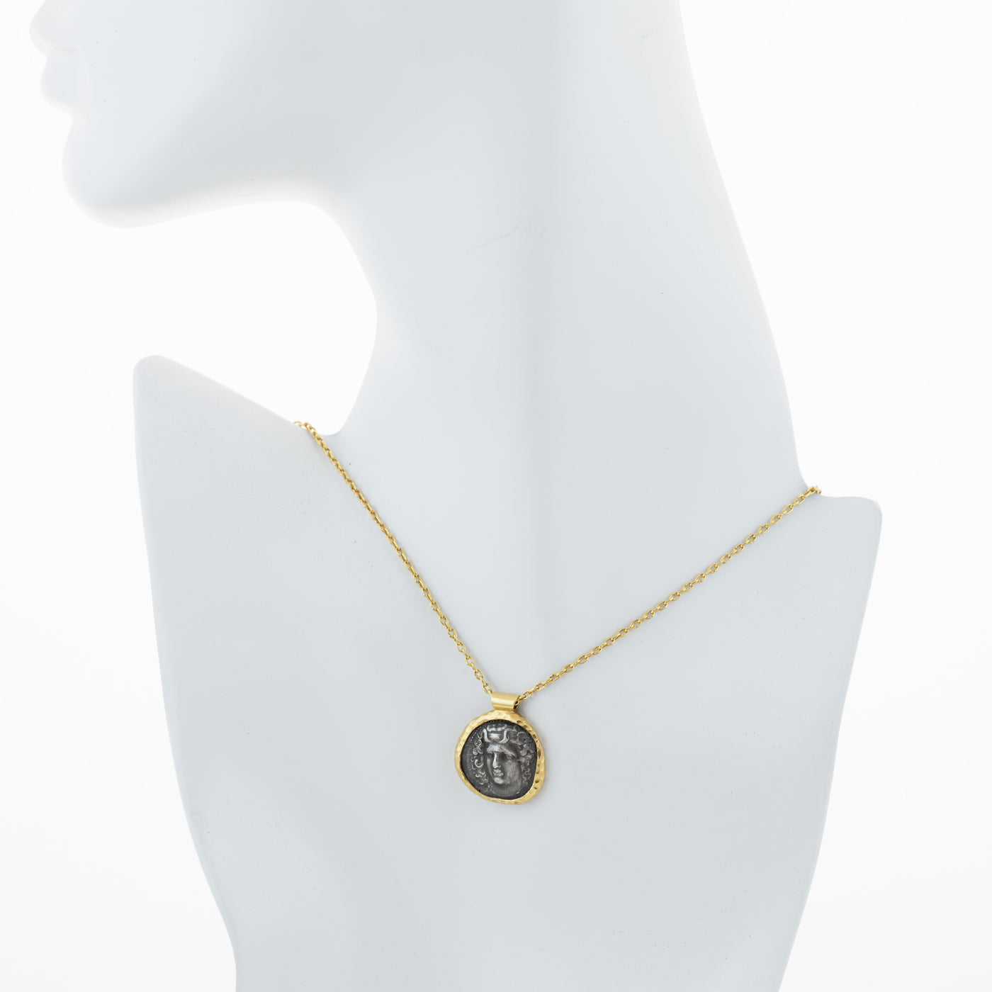 Gold necklace with an ancient coin pendant on a white mannequin