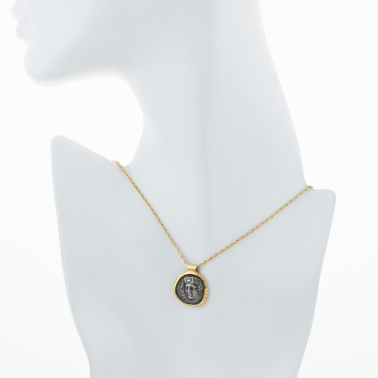 Gold necklace with an ancient coin pendant on a white mannequin