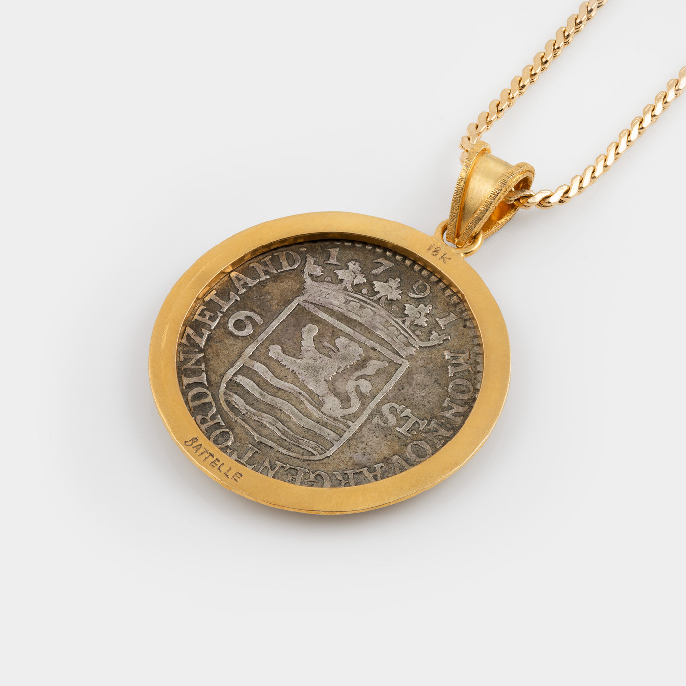 A gold pendant necklace featuring a circular coin pendant with a silver-toned lion design and gold border, suspended from a gold chain against a light gray background.