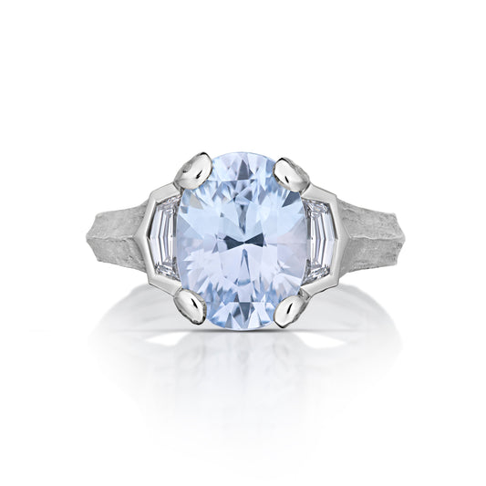 Front view of platinum ring with a large blue gemstone on a white background
