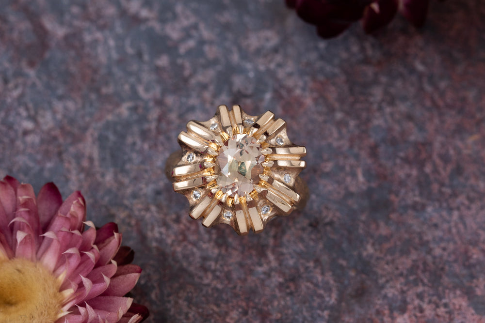 Floral gold ring on a slate background with flowers
