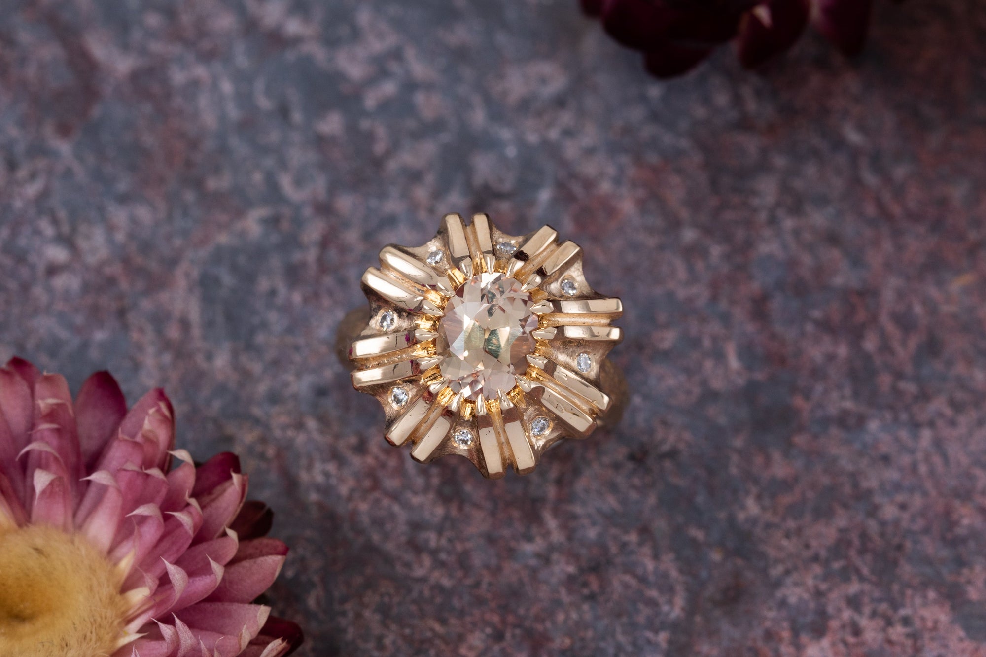 Floral gold ring on a slate background with flowers
