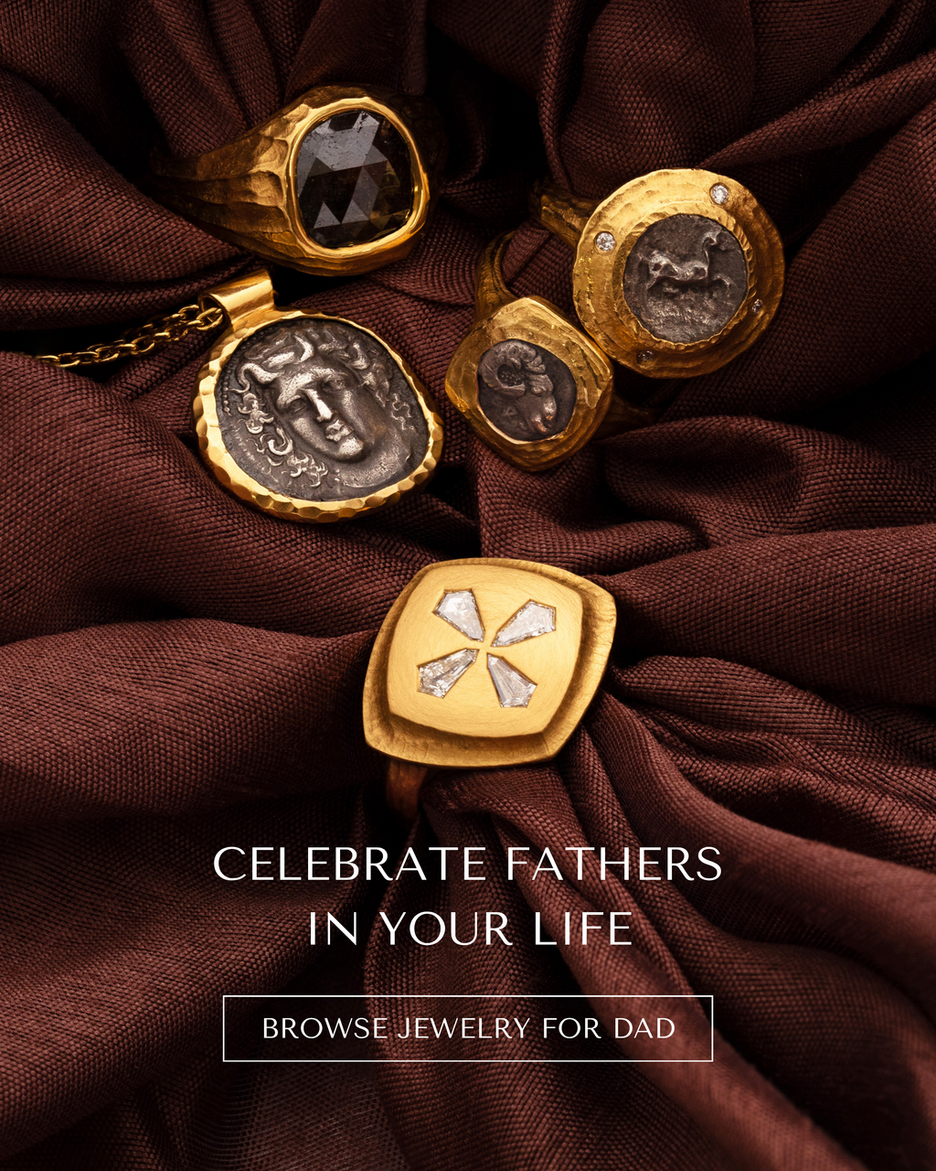 Image: Rings and necklaces on a dark brown cloth background Text: CELEBRATE FATHERS IN YOUR LIFE [BROWSE JEWELRY FOR DAD] button.