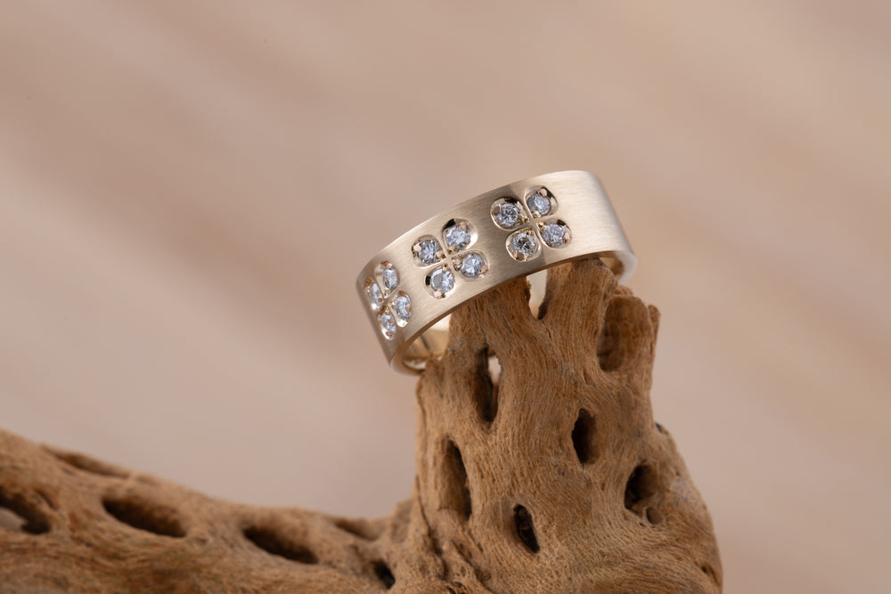 Gold ring with embedded diamonds on a textured brown surface