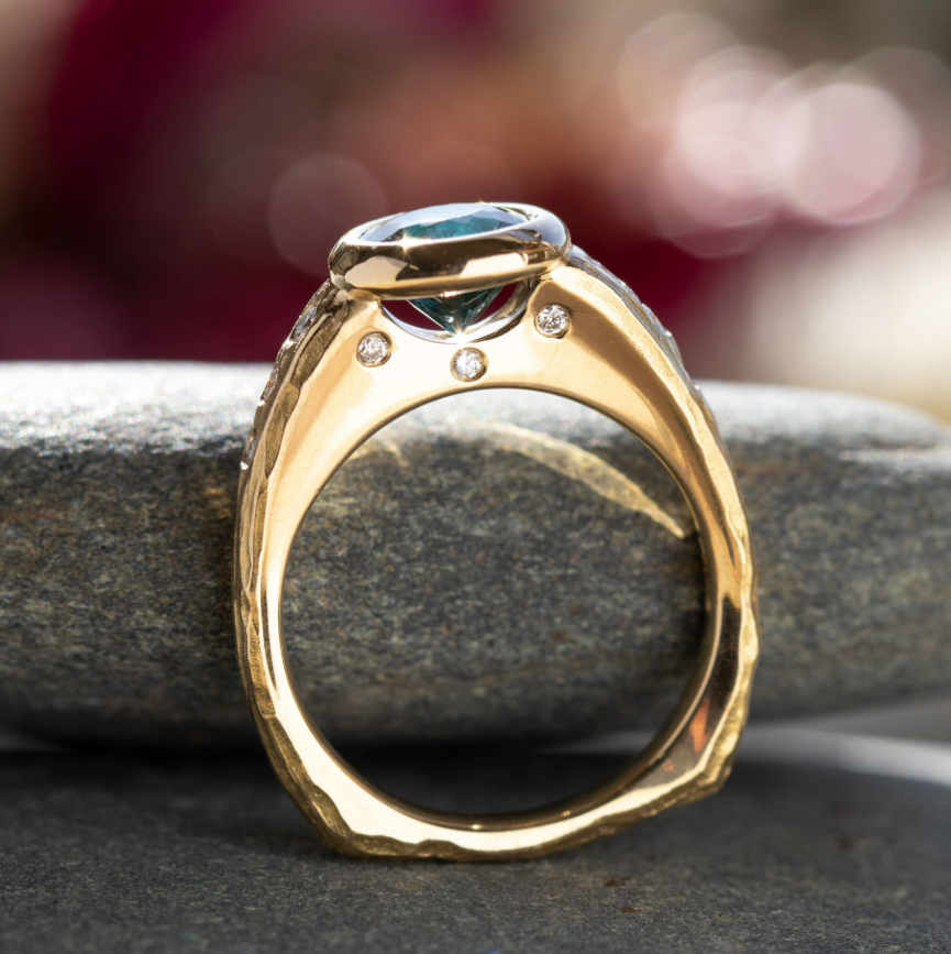 Side Profile of a Gold Ring with 3 side stones and a main teal stone in bezel setting