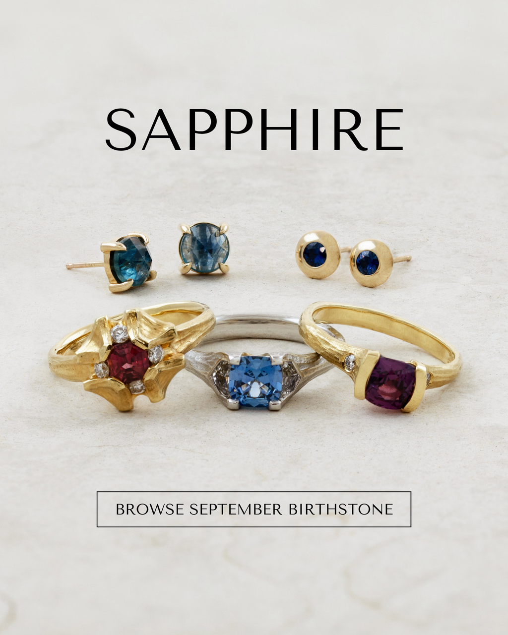 Image: A promotional banner for jewelry featuring gold rings, necklaces and earrings with multicolor gemstones on a tan tile background, with the text 'SAPPHIRE' and 'BROWSE SEPTEMBER BIRTHSTONE'.